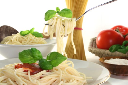 Spaghetti on a fork with tomato sauce and fresh basil