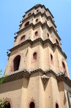 Bottom view of an ancient Chinese pagoda against blue sky