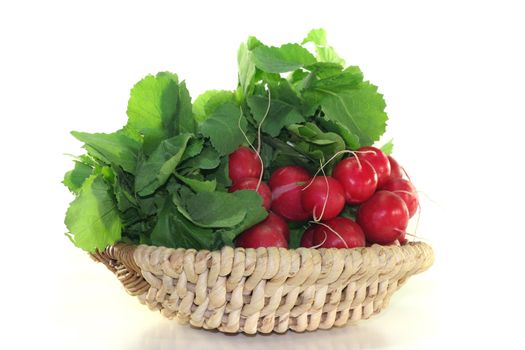 fresh radishes with green leaves in a basket of bast