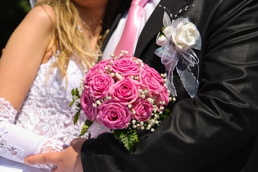 Bridal bouquet in the hands of bride and groom