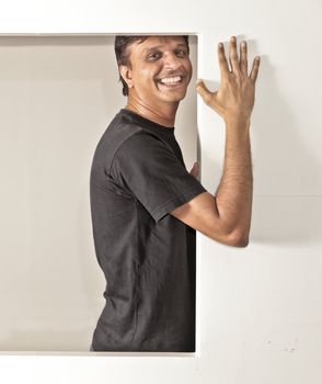 young man holding on to a partition wall preventing it from falling