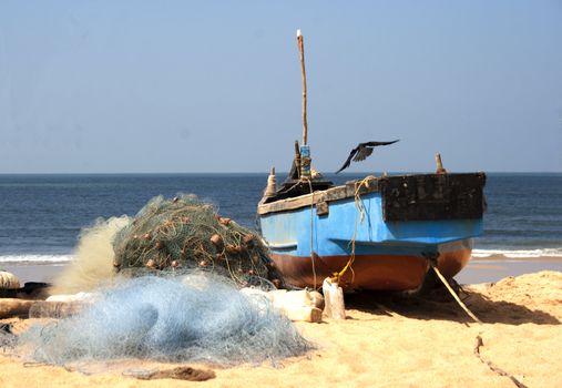 berthed fishing vessels on the beach with nets, copy space