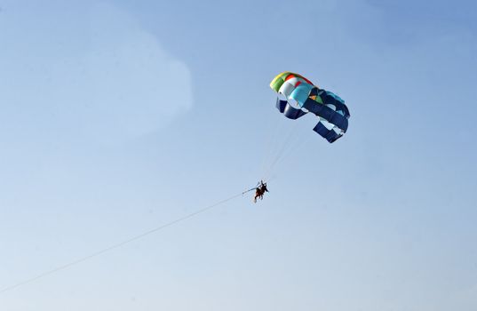 para sailers beach sports Calangute Goa India through blue sky wispy clouds