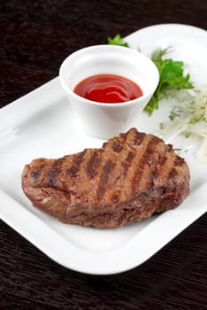 Juicy roasted beef steak with vegetables closeup at plate