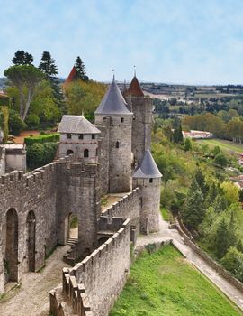 Image of towers of the wall surounding the fortified town of Carcassonne.The tower with a square shape is the Bishop's Tower.In front of it is a round-shaped tower which is the Inquisition tower. Carcassonne is a very famous fortified medieval town located in the Languedoc-Roussillon (Aude department) region in the South of France. 