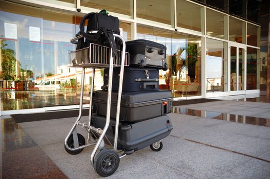 Trolley with suitcases in front of hotel