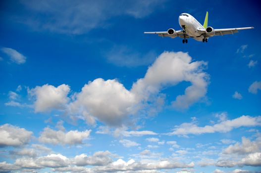 Air travel - Plane flying in blue and cloudy sky.