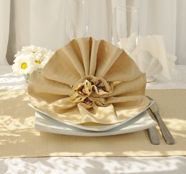 Coordinated decorative napkin on a plate with cutlery