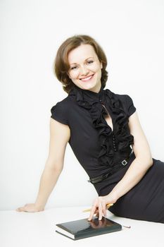 smiling attractive young woman in business black dress sitting on the table
