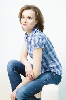 attractive young girl in jeans sitting on the couch home

