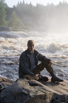 Portrait of young man near rapid.
