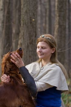 Portrait of the girl and irish setter in autumn forest.
