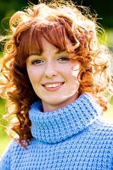 Close-up bright portrait of red-haired lovely young woman outdoors