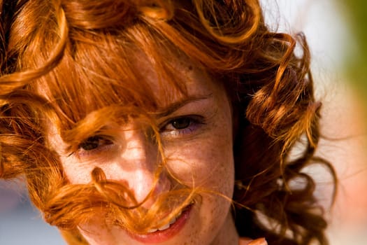 Close-up bright portrait of red-haired lovely young woman outdoors