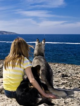 Woman and her two pet dogs by the coast