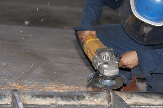 a picture of a worker grinding steel