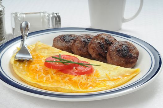 Cheddar cheese omelet served with pork sausage.