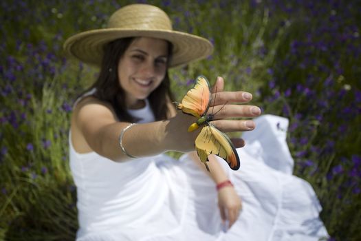 young girl in white dress holding orange butterfly