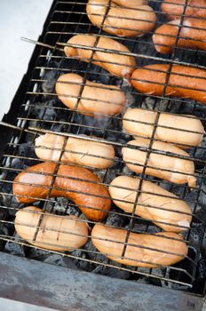 grilled sausages on grill, with smoke above it