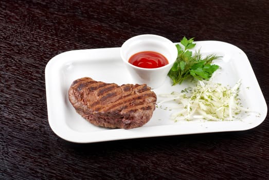 Juicy roasted beef steak with vegetables closeup at plate