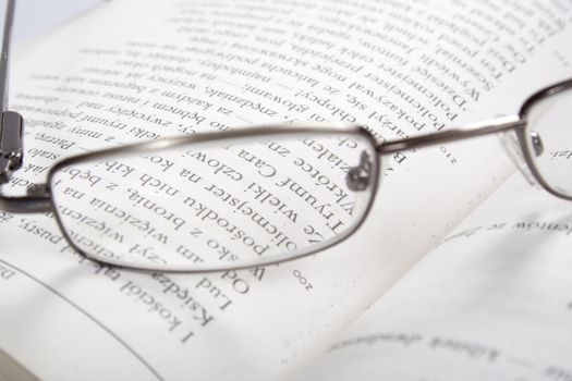 the reading glasses on a open book