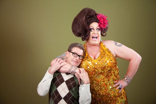 Large drag queen holds a surprised nerd around his neck