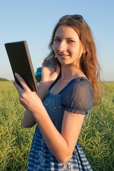 Teen girl with electronic book reader outdoors