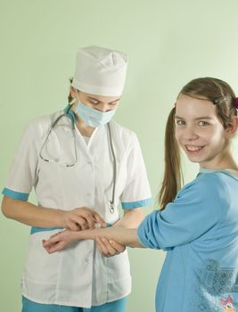 Lady doctor making an injection to smiling teen girl