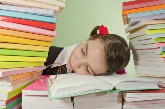 Teen girl sleeping on the stack of books