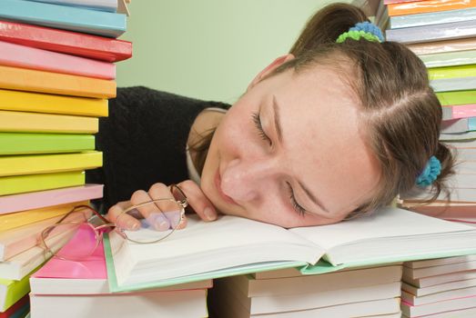 Girl student sleeping on the stack of books