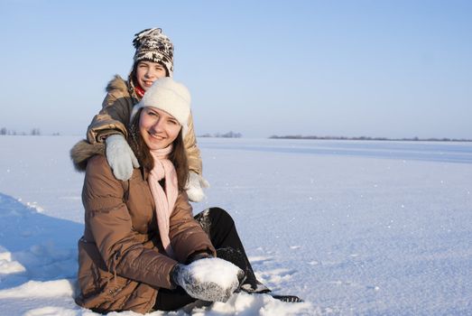 Teen girls sitting in snow