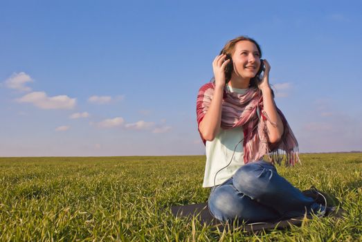 Girl with headphones listening music outdoors