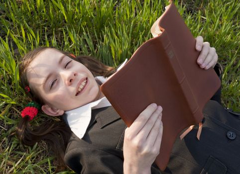 Girl with the Bible laying on the grass