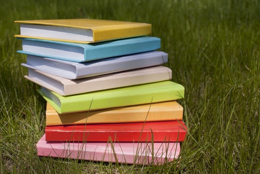 Stack of the books laying on the grass