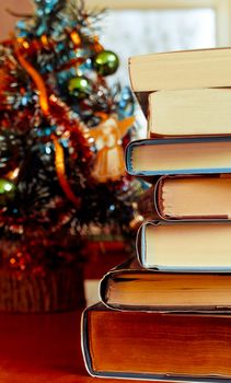 Books laying in front of Chrismas tree