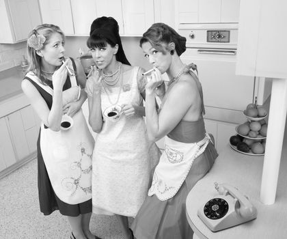 Three beautiful retro-styled women enjoy cup of coffee with cigarette