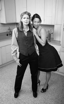 Two happy women standing together in kitchen