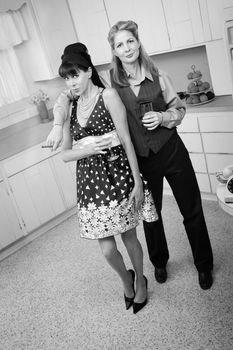 Two middle-aged women enjoy a cigar and a drink