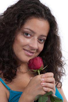 Young lady posing with a rose in a studio with white background.