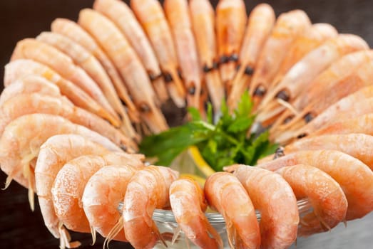 tasty shrimps with lemon and greens closeup