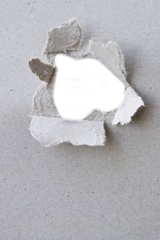 torn hole in sheet of paper with white background and copyspace