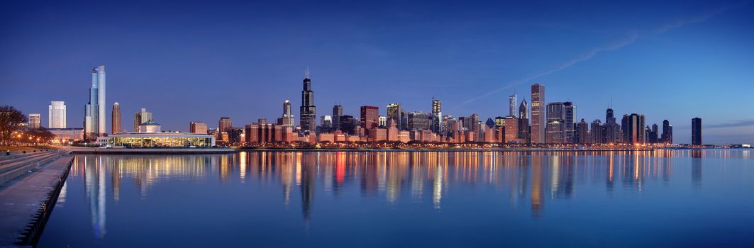 Chicago city skyline in the evening with reflection of the skyscrappers on the water