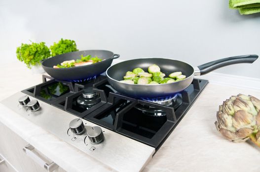 Red fish with mint and lemon prepared in a black skillet in the kitchen