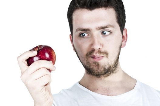 Isolated image of a young man staring at a red apple with hunger