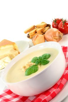 a bowl of cheese soup with croutons and basil