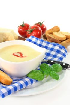 a bowl of cheese soup with croutons and basil