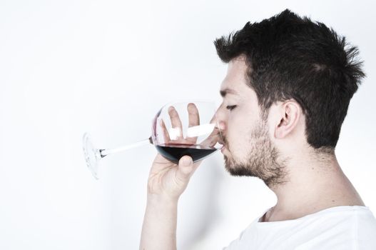 ısolated image of a young man drinking a glass of red wine