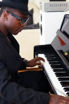 Black musician plays the piano - photographed from the side