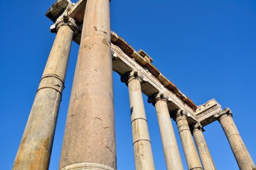 Ancient marble columns against a blue sky. Rome, Italy