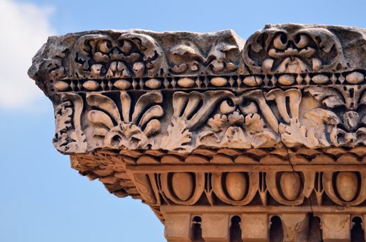 Ancient marble capitel against a blue sky. Rome, Italy